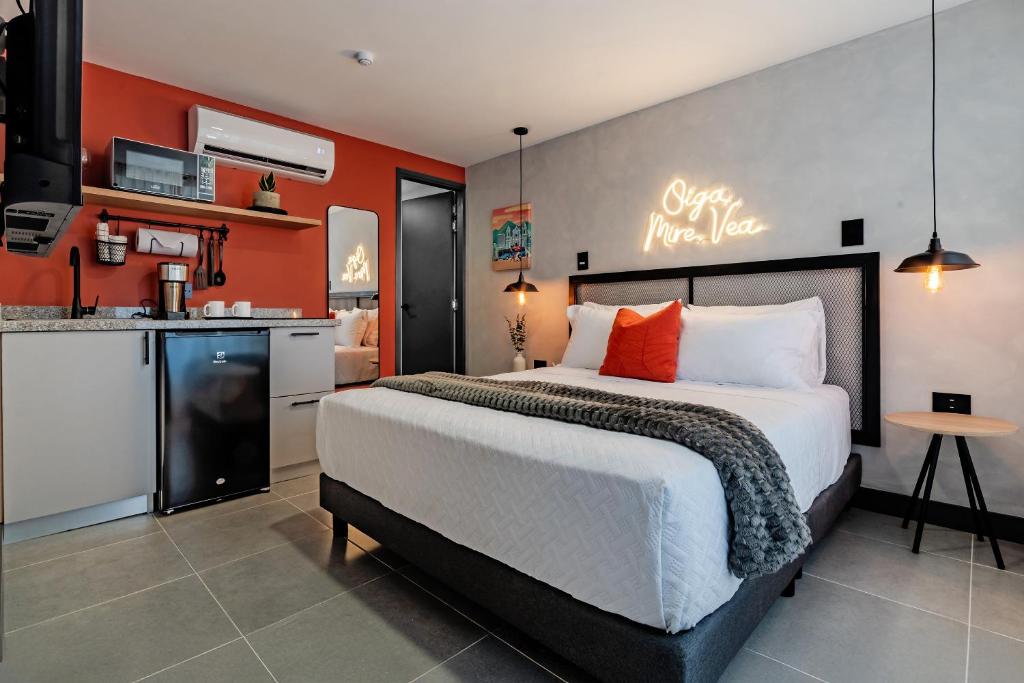 a bedroom with a large bed and a kitchen at Sueño Caleño in Cali