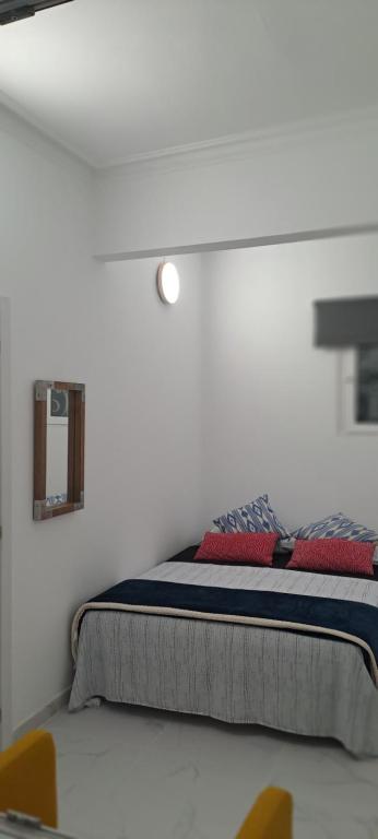 a bed in a white room with two chairs at City Haven Palma in Palma de Mallorca