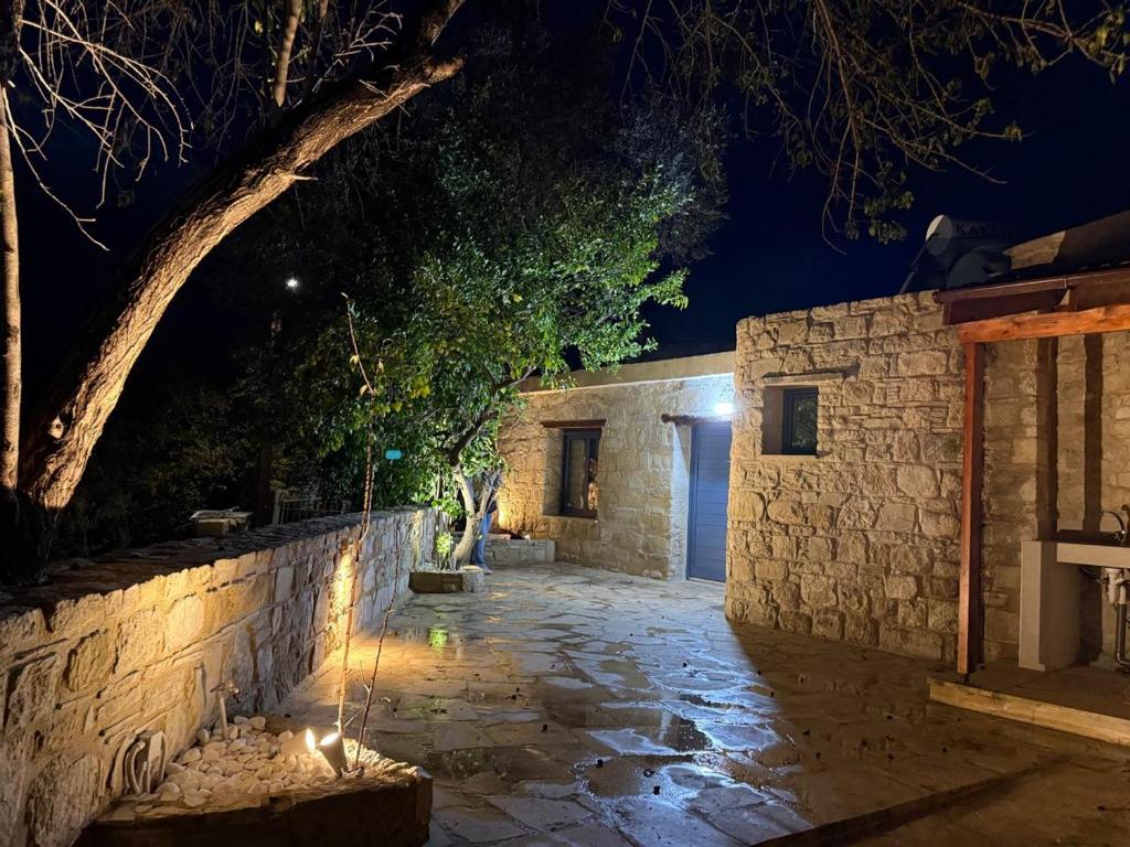 a stone building with a stone wall at night at 'I Elea' Village House with Courtyard in Letimbou