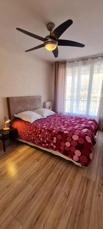 Appartement VANILLE في لو بونت دي كليكس: غرفة نوم بها سرير ومروحة سقف