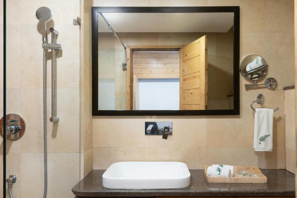 un baño con lavabo y espejo en The Fern Brentwood Resort, Mussoorie, Series by Marriott, en Mussoorie