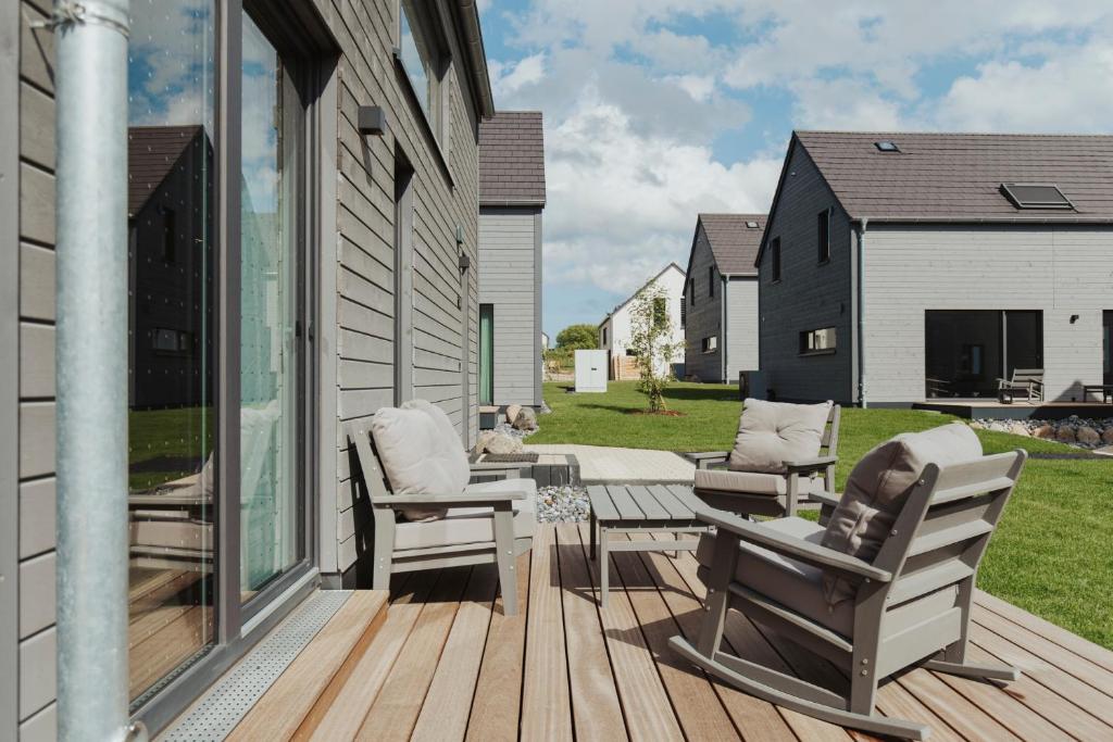 a patio with chairs and a table on a deck at "Rügen Resort Sagard" großzügige, gemütliche Doppelhaushälfte "Anneke" mit Terrasse in Sagard