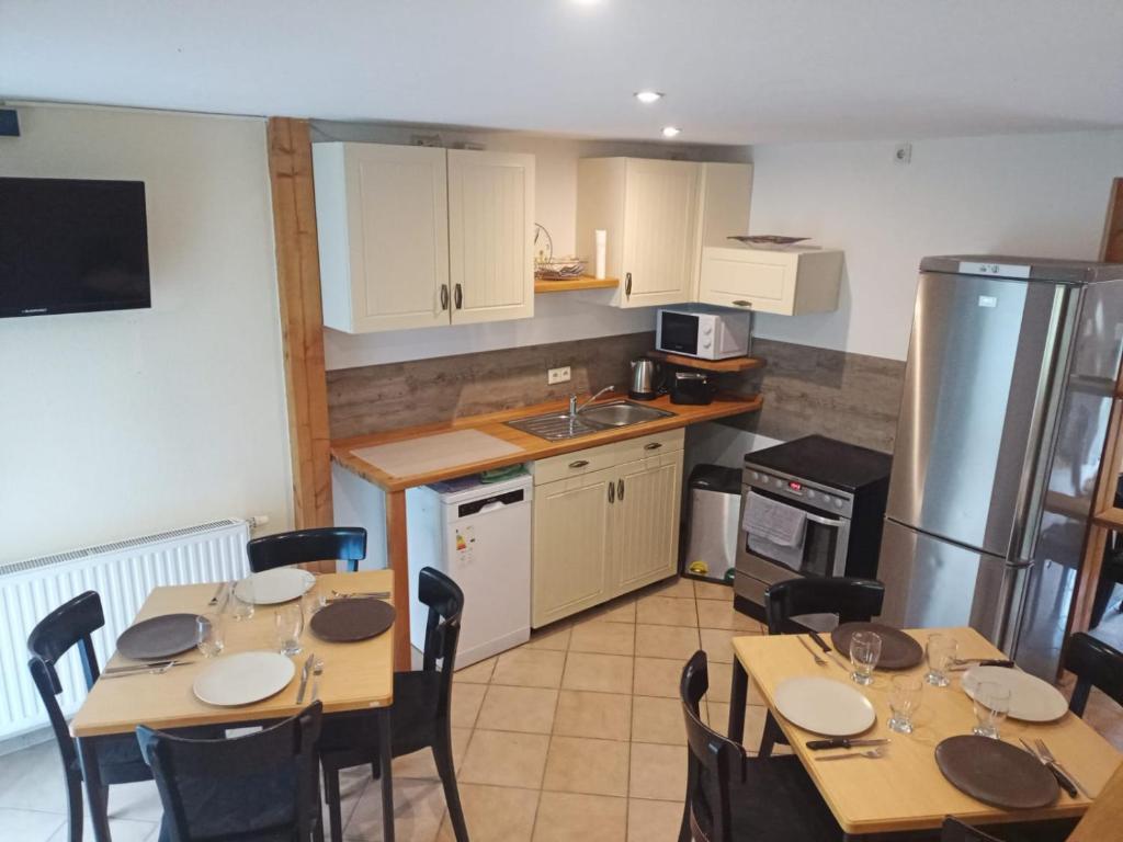 Großes Haus bei Rostock Lüsewitzer Krug bis 10 Personen في Klein Lüsewitz: مطبخ بطاولتين ومطبخ مع ثلاجة