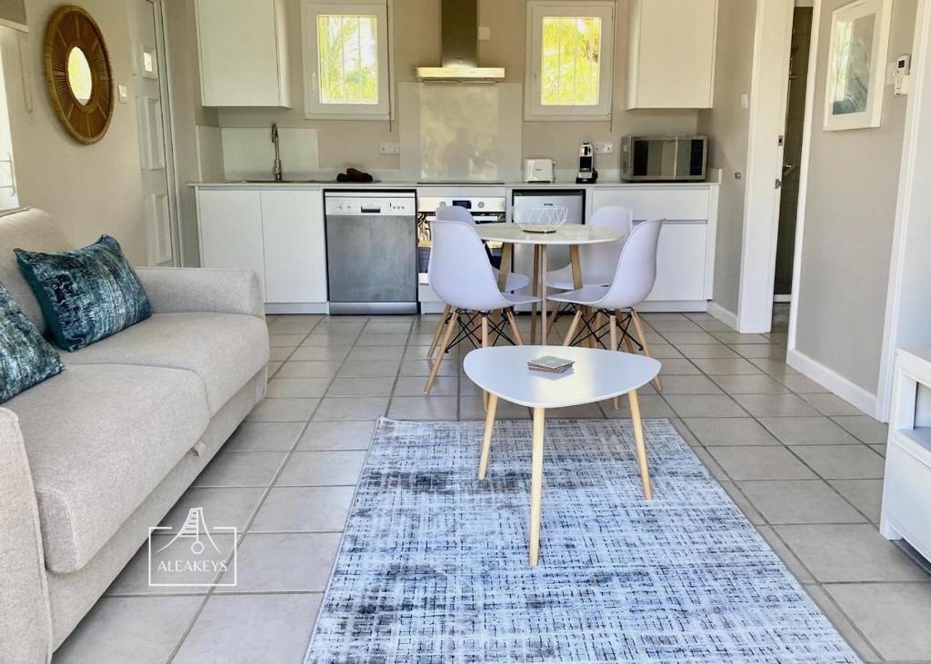 Villa Le Coin - T2 moderne climatisé avec Wi-Fi في Midlands Station: غرفة معيشة بها أريكة وطاولة