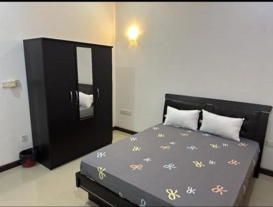 una camera da letto con un letto nero e fiori sopra di Royal Wings Villa a Negombo