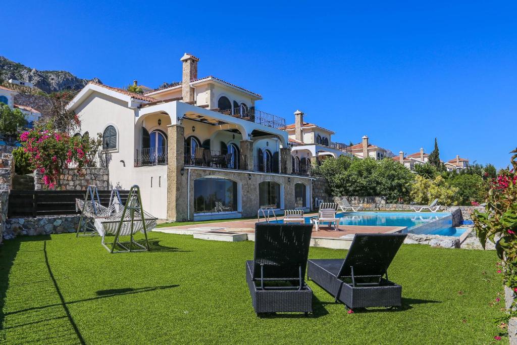 a large house with two chairs in the yard at Villa Sakura in Kyrenia