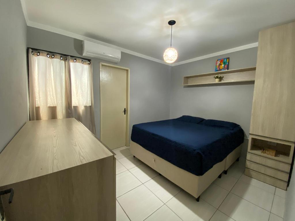 a bedroom with a blue bed in a room at Apartamento á 5 minutos do centro in Garanhuns