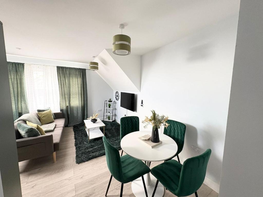 Una sala de estar con una mesa y sillas verdes. en Elegant Retreat 6 Mins Drive from Ferry With Free Parking, en Dover