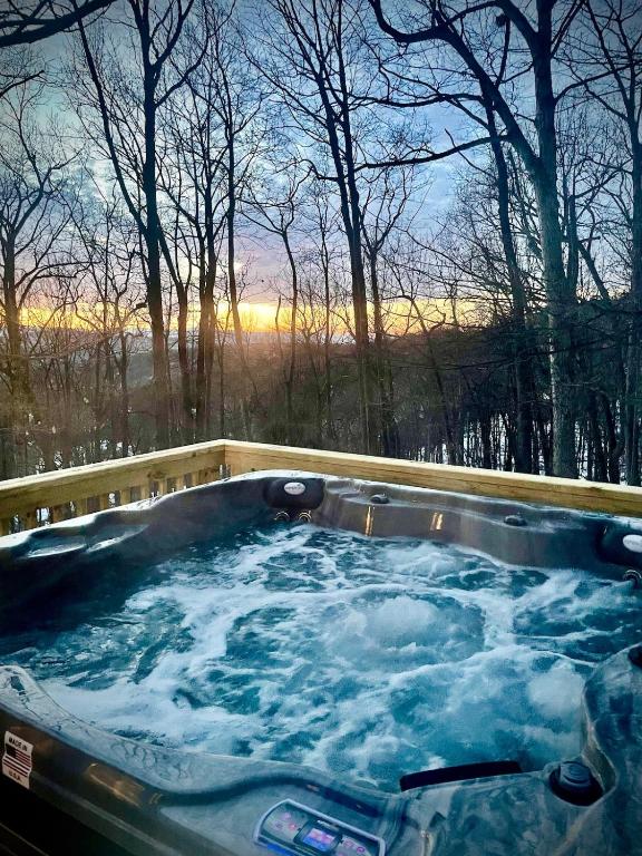 a jacuzzi tub with snow on it in the woods at Apple Mountain Retreat at Shenandoah National Park 