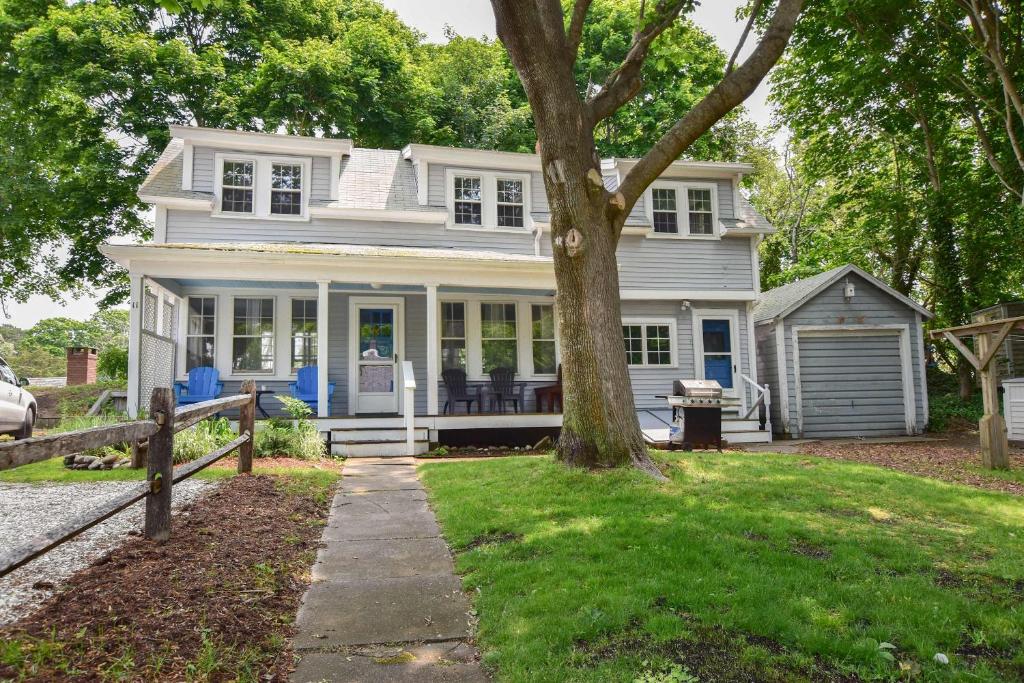 a white house with a tree in the yard at Walk to Restaurants Shopping & Harbor in Wellfleet