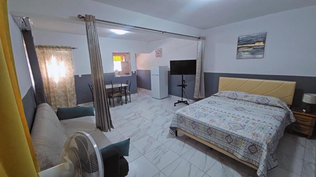 a bedroom with a bed and a couch at Ecofriendly Apartment in Gated Residence in Saint Martin