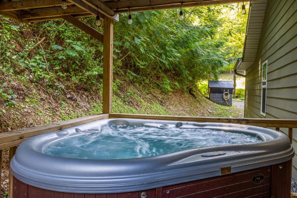 a jacuzzi tub in the backyard of a house at Rustic Retreat — Easy Access, Peaceful Setting, Close to Everything in Sevierville