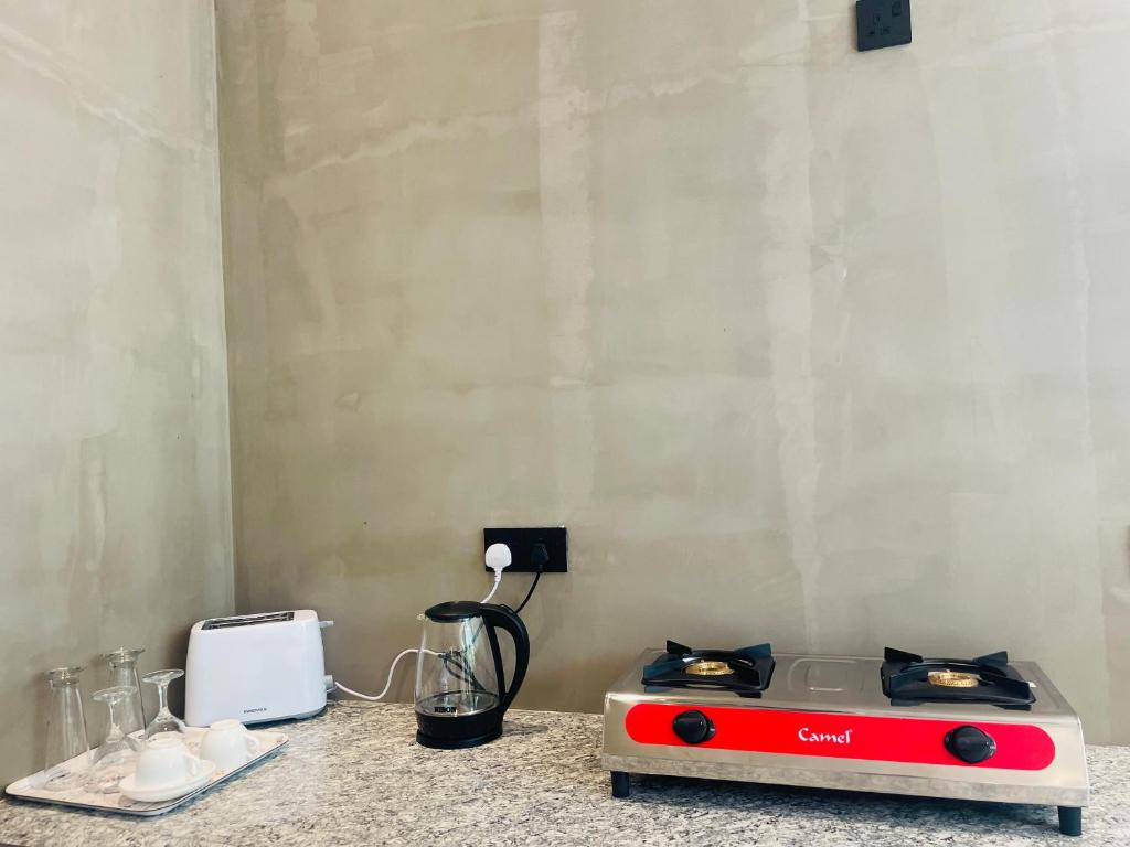 Una cocina con una estufa roja y blanca sobre una encimera. en Bella Nova, en Ahangama