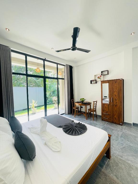 a bedroom with a large white bed and a table at Bella Nova in Ahangama