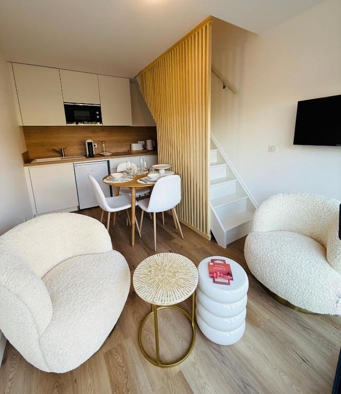 a living room with two chairs and a table at Studio Spa Du Bassin in Le Teich