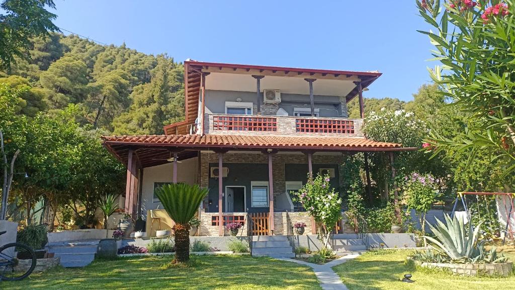 a house with a balcony on top of a yard at Villa Dallas-Beach,Bike & Gym in Vourvourou