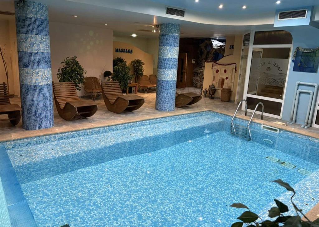 a large swimming pool in a room with chairs at Hotel Premier - Veliko Tarnovo City Center, Panorama View in Veliko Tŭrnovo