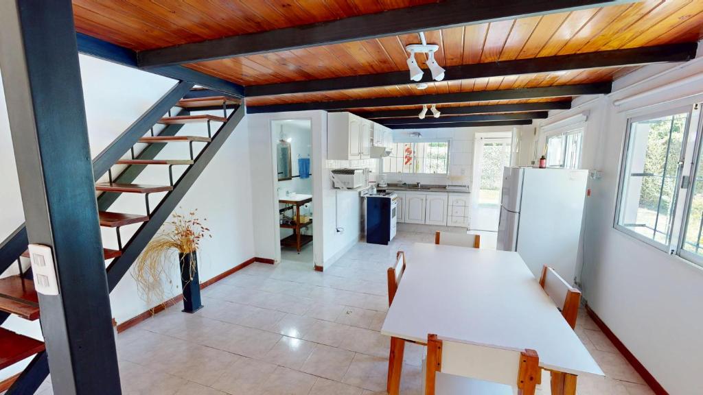 a kitchen with a white table and a staircase at Casa Tipo Loft- Tigre Centro Con Jardin, Parrilla - 4 Personas in Tigre