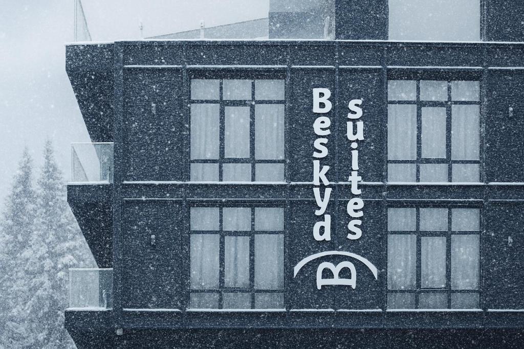 a building with a sign on it in the snow at Beskyd Suites in Bukovel