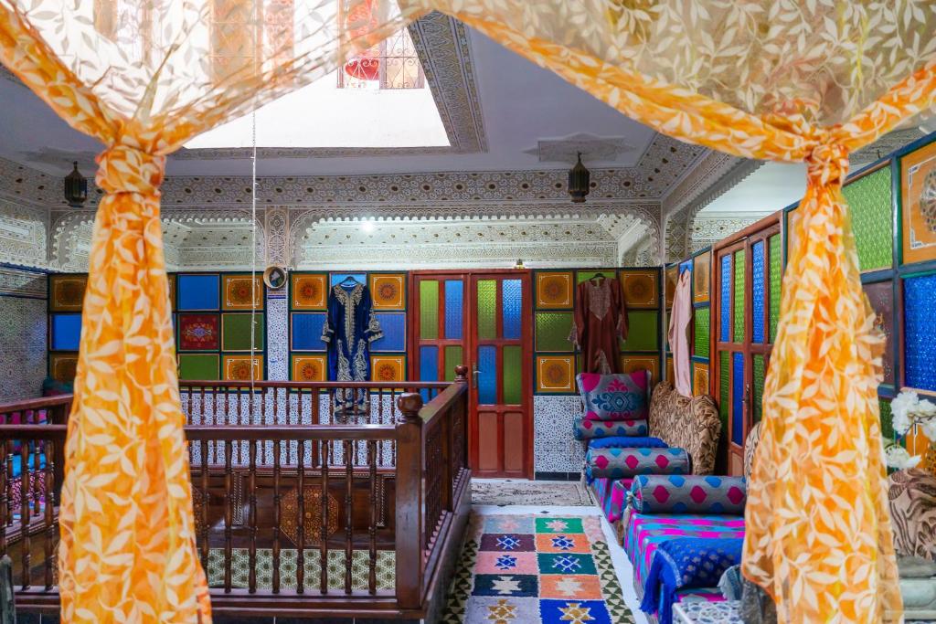 a room with a crib and colorful walls at Dar Merzouga Meknes in Meknès