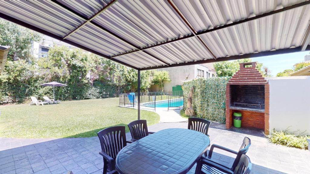 a patio with a table and chairs under awning at Casa Amplia 5 personas Con Pileta, Amplio Jardin y Parrilla Zona Muy Tranquila en Tigre Centro in Tigre