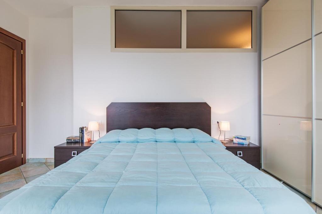 sypialnia z dużym łóżkiem z niebieskimi poduszkami w obiekcie Residenza Maria Antonia - Private Apartment w mieście Orosei