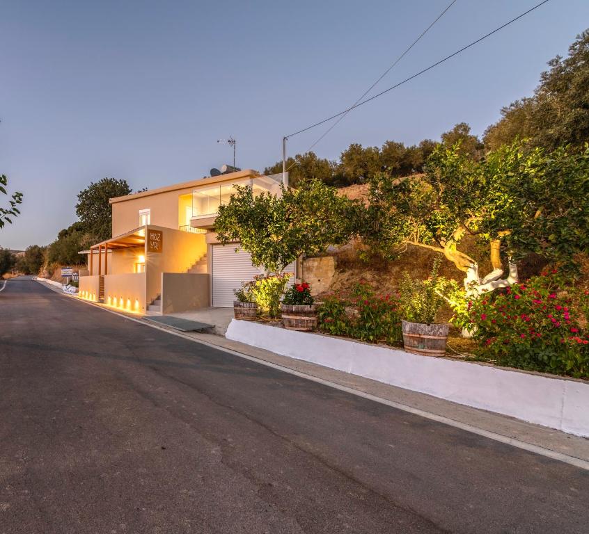 a house on a street with flowers and plants at Huzuri Retreat in Ayiós Nikólaos