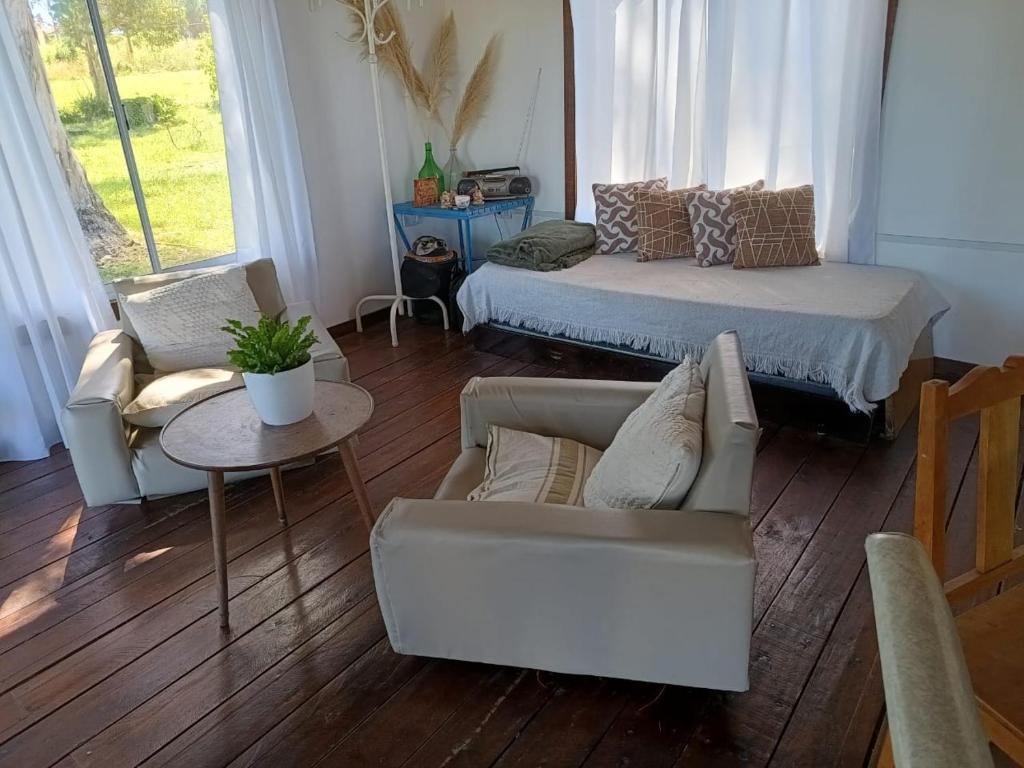 Una sala de estar con una cama, un sofá y una mesa. en Kiya surf hostel, en Colonia Chapadmalal