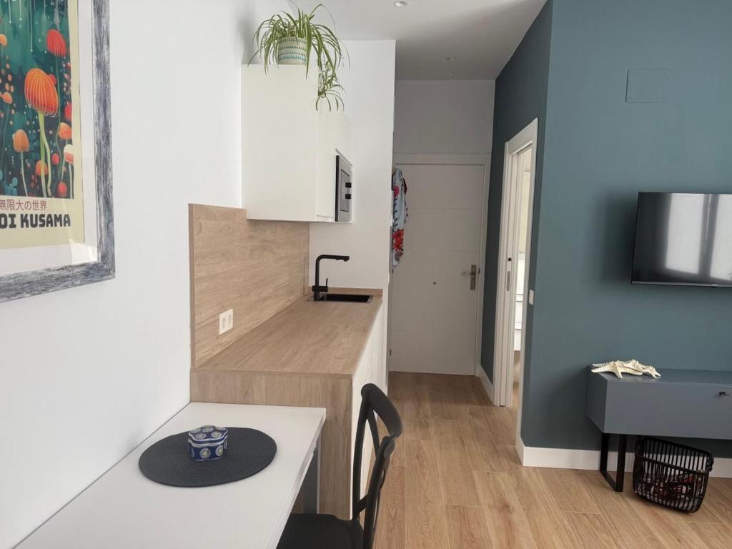 Una pequeña cocina con una mesa y un fregadero. en Alojamientos Dima Costa, en Laredo