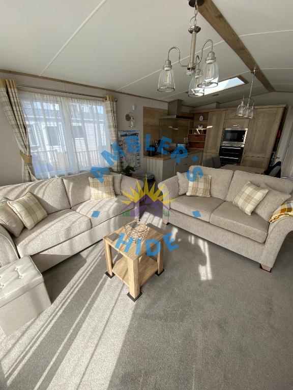 a living room with two couches and a table at Amblers Hide, Brigham, Cockermouth, Cumbria in Cockermouth