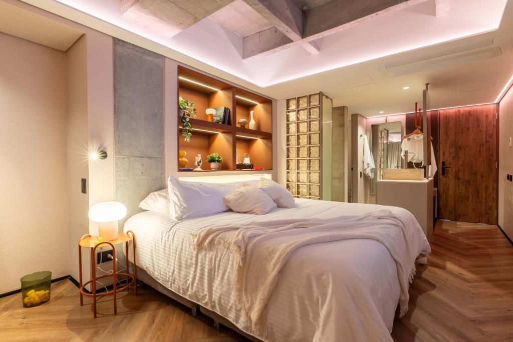 una camera da letto con un grande letto bianco in una stanza di BoH Manila a Medellín