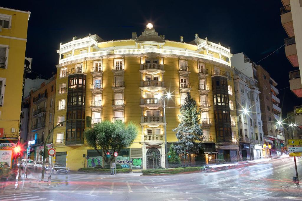 a large yellow building with a christmas tree in front at Hurtado de Mendoza by Cuencaloft in Cuenca