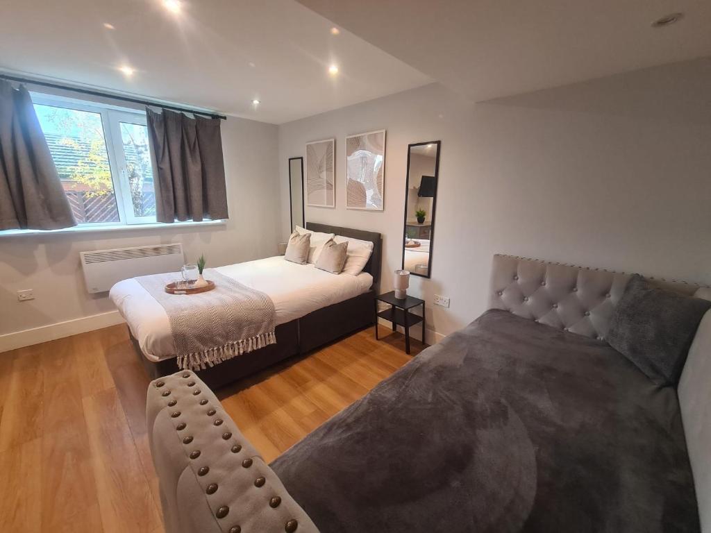 a bedroom with a bed and a couch and a window at City Centre Studios in Newcastle upon Tyne