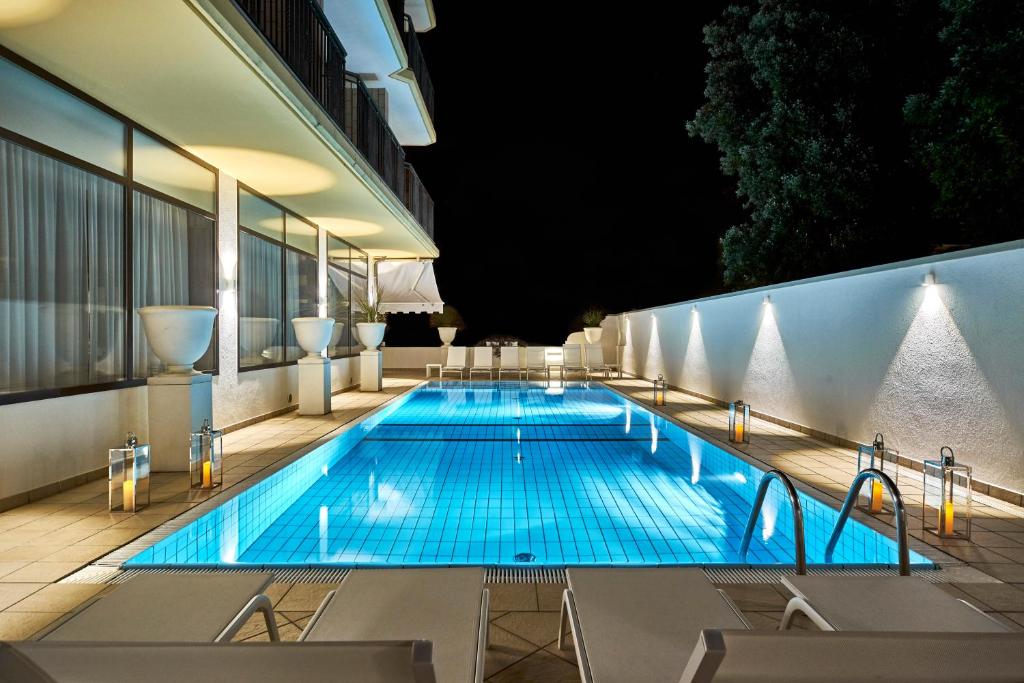 a swimming pool on the roof of a building at night at Palace Hotel Regina in Bibione