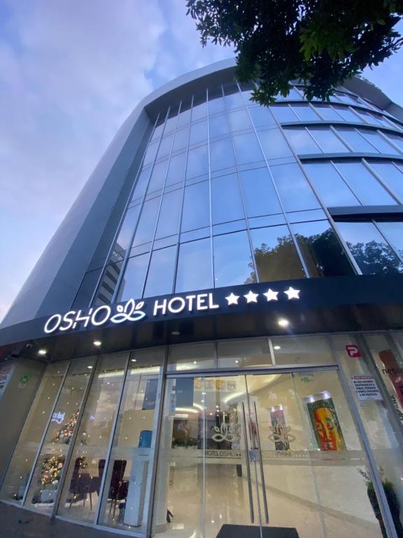 a building with a sign on the front of a store at OSHO Hotel in Santa Cruz de la Sierra