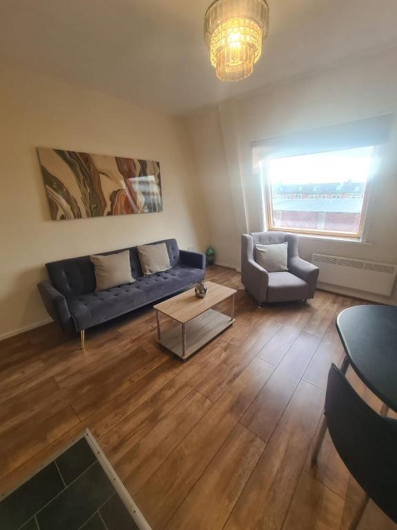 a living room with a blue couch and a chair at Tyneside 2 beds in Gateshead