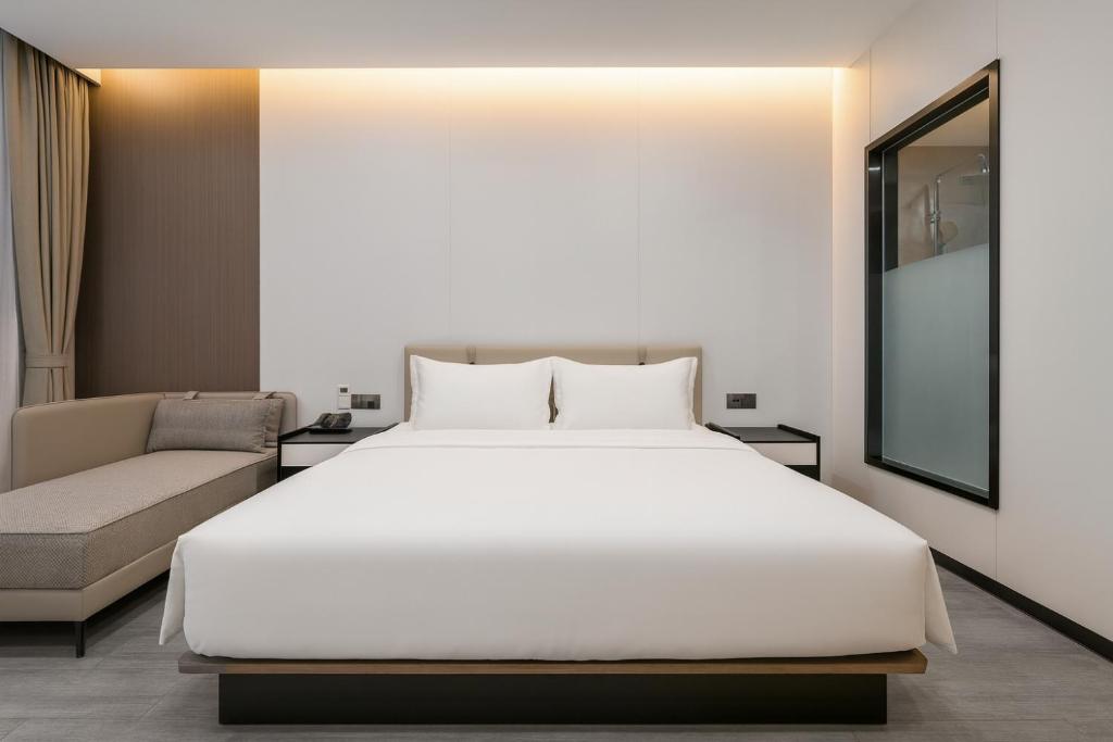 a bedroom with a large white bed and a couch at 东方酒店 in Sihanoukville