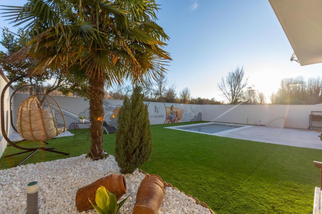 un cortile con un campo da tennis e una palma di La Villarina 
