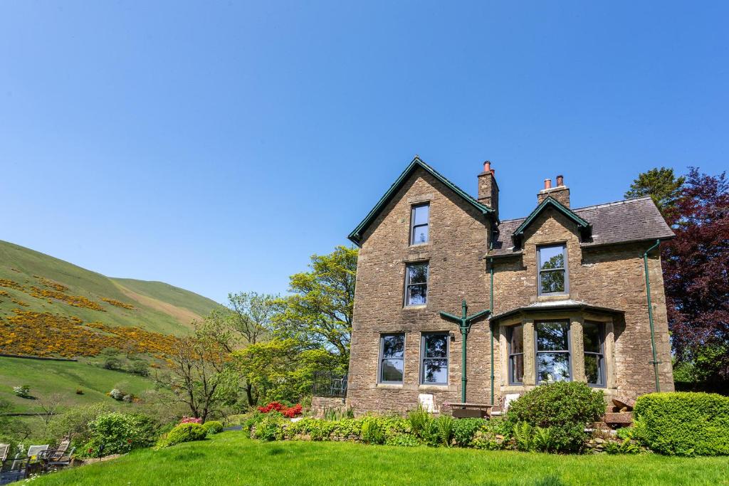 a large brick house on a grassy hill at St Marks Stays in Sedbergh