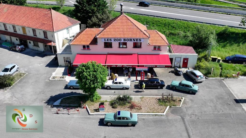 una vista in alto di un edificio con auto parcheggiate in un parcheggio di Logis Hôtel Les 200 Bornes a Pouilly-sur-Loire