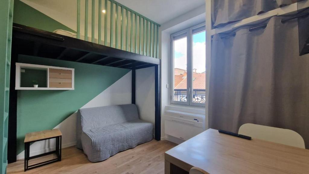a room with a loft bed with a chair and a window at Studio Cosy - Proche Tram et Gare de Grenoble in Fontaine