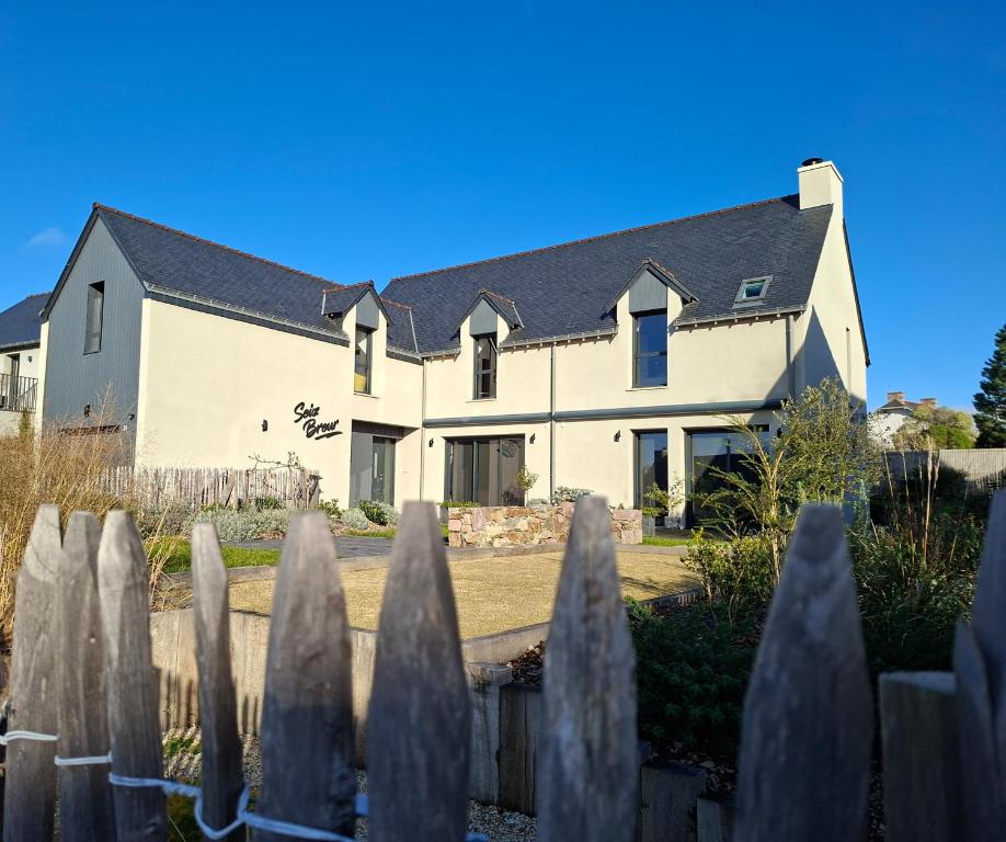 een wit huis met een hek ervoor bij Chambre d'hôtes Seiz Breur in Lancieux