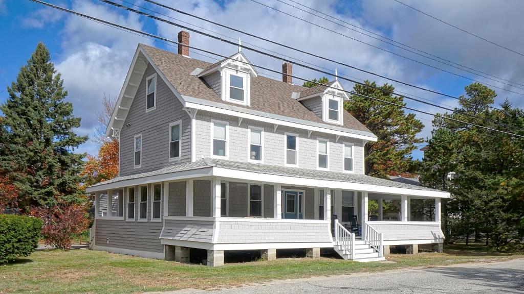 une grande maison blanche avec un porche dans une rue dans l'établissement A Shore Thing, à Surfside