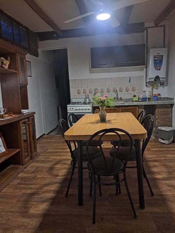 a kitchen with a wooden table with chairs and a stove at Suspiros De Mendoza in Barraquero