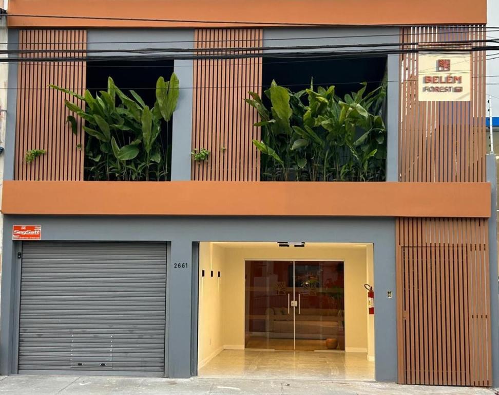 un edificio con dos puertas de garaje y macetas en Belém Forest Inn, en Belém