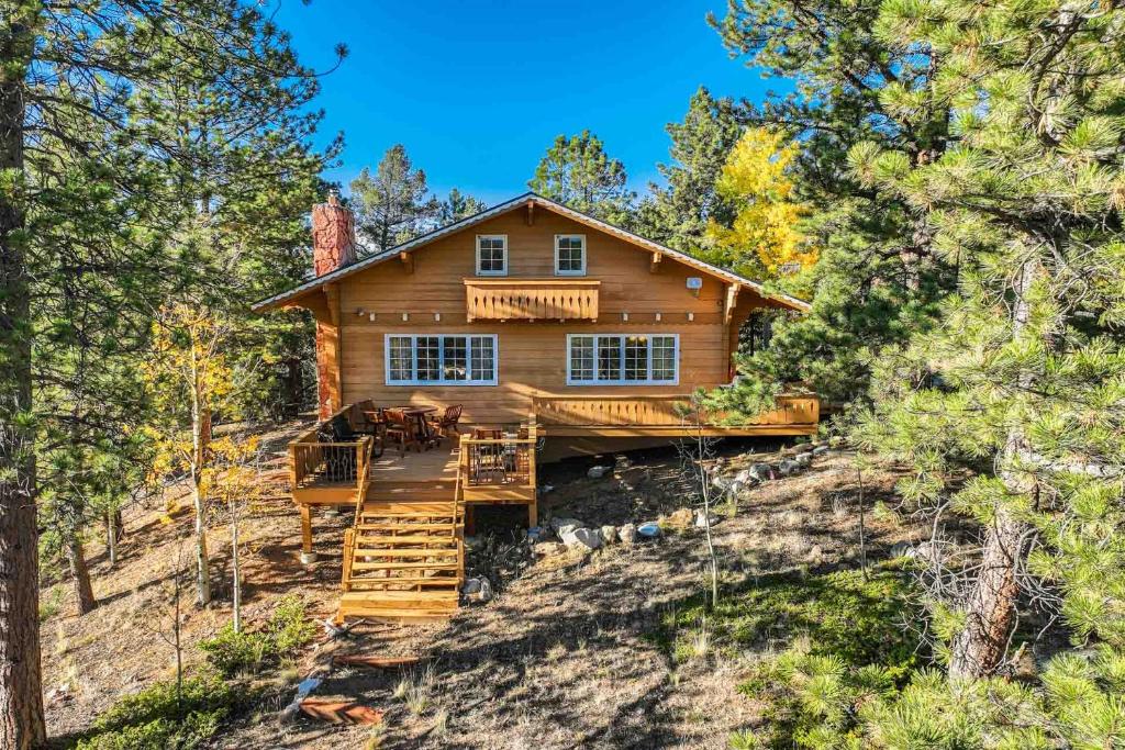 a log home on a hill with a staircase and a house at CrazyHornChalet in Divide