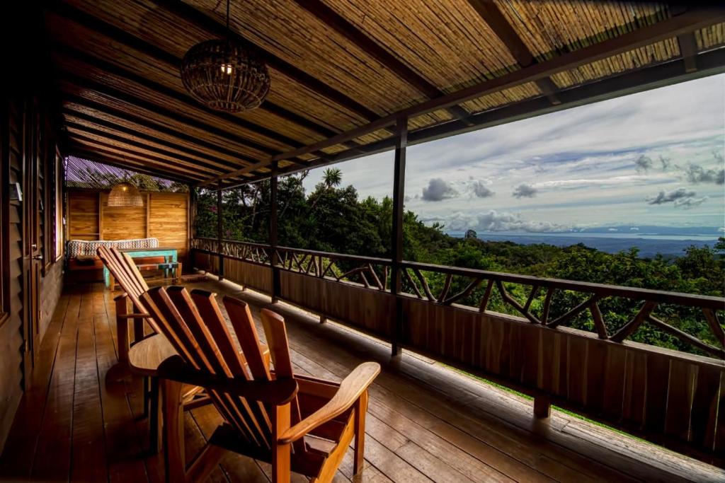 Casa Cabuya - Retro Style with Gulf View in Monteverde في مونتيفيردي كوستاريكا: شرفة مع كرسيين وطاولة على شرفة