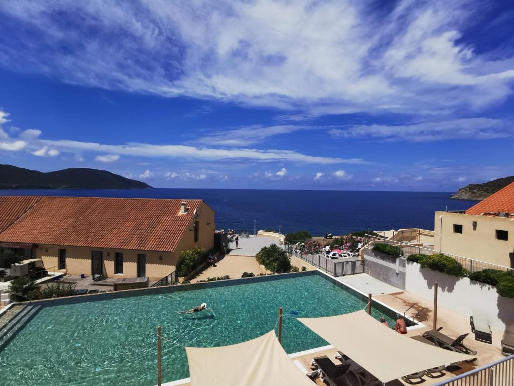 una piscina con l'oceano sullo sfondo di Village de vacances Paese di Lava, Grand Ajaccio ad Alata