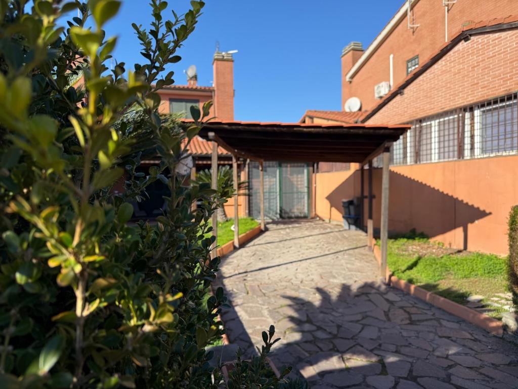 een loopbrug naar een gebouw met een dak bij Green Luxury House in Casal Palocco