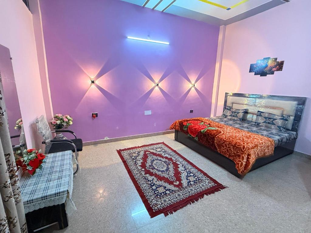 a bedroom with a bed and a purple wall at Dev Paradise Ayodhya in Ayodhya